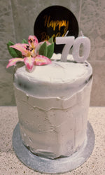 Load image into Gallery viewer, naked birthday cake with pink flower and number 70 candles. 

