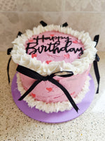 Load image into Gallery viewer, Pink birthday cake with white buttercream, black 'Happy Birthday' sign, and a black ribbon bows.
